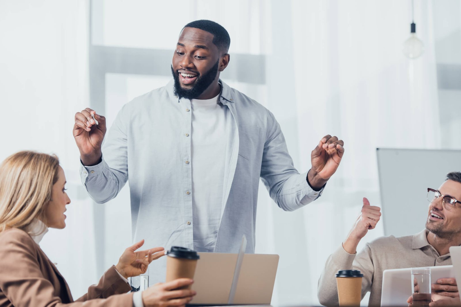 african-american-man-talking-with-colleagues-during-meeting-in-creative-agency.jpg